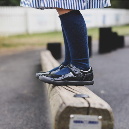 Girls standing on wood beam at school in black school shoes