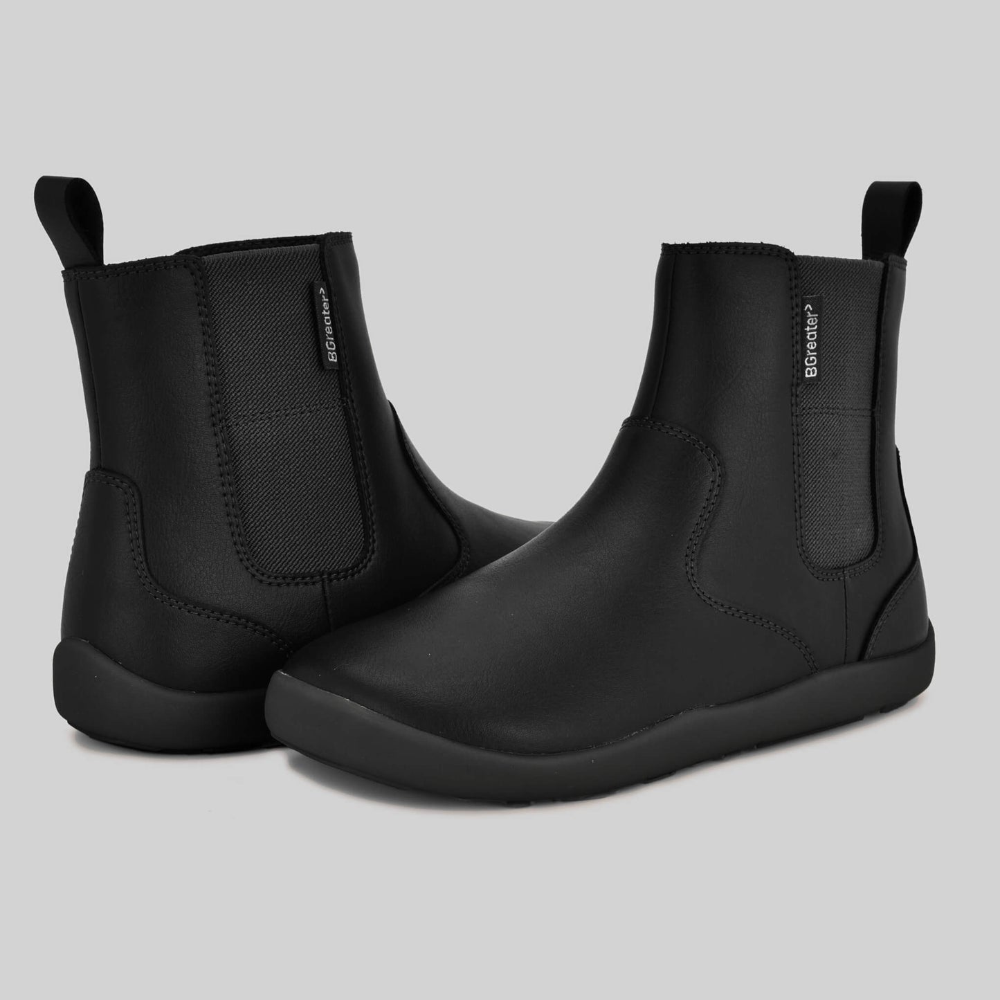 Girls black Chelsea Boots pair facing each other